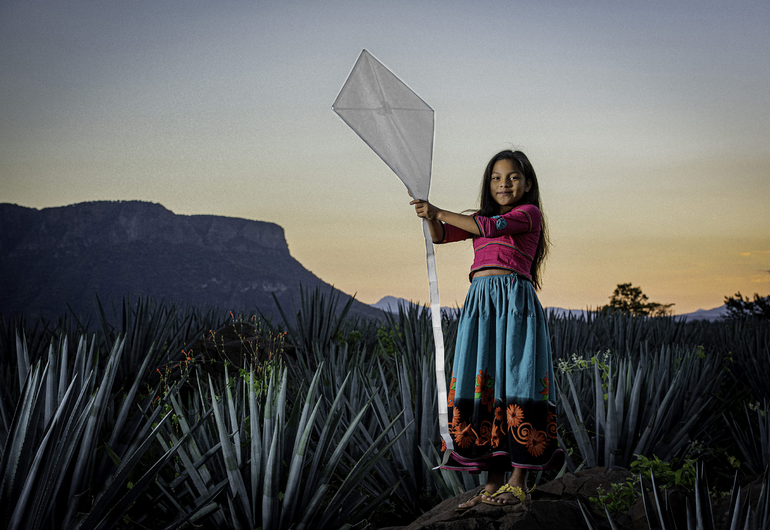 Niña con papalote al amanecer